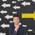 Man standing in front of directional arrows pointing left and right