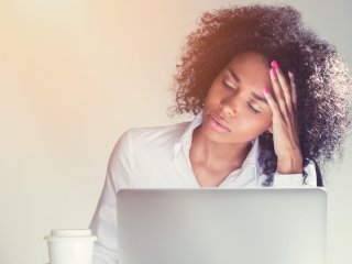 Stressed young female professional at laptop